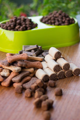 Dog tasty colored biscuits on wooden background, bowl