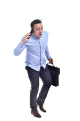 Young man wearing a blue shirt and grey trousers pulling faces, smiling while holding a briefcase isolated on white background.