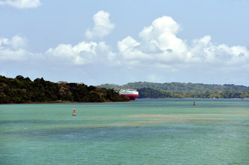 Landscape of the Panama Canal, with car carrier ship on the horizon. 