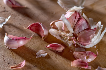 head of garlic with husk on a cutting board