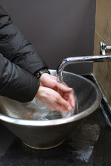 A man washing his hands with soap in a public place. Virus prevention. Close up Hygiene concept. Measures to stop coronavirus pandemic.