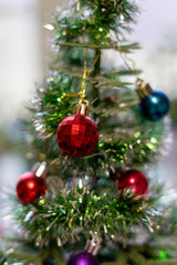 bright Christmas balls on a decorative small Christmas tree