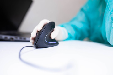 Fototapeta premium hand of a medical scientist in a medical glove uses a vertical ergonomic computer mouse-joystick. prevention carpal tunnel syndrome