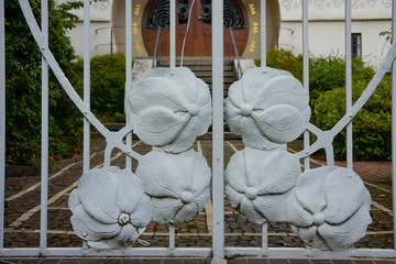 part of a forged iron gate. in gray with stylized Art Nouveau flowers