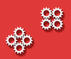 White connecting gear cogs isolated on red background; two groups of four elements; flat lay, close up; copy space, top view 3d rendering, 3d illustration	