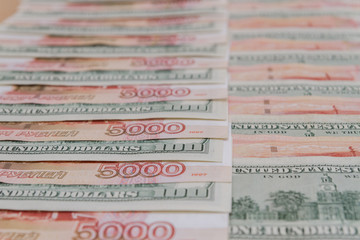 A large number of American hundred dollar bills and Russian five thousand dollar bills