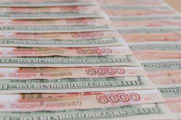 Fototapeta premium A large number of American hundred dollar bills and Russian five thousand dollar bills