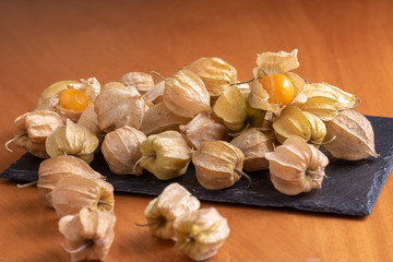 Ripe physalis isolated on a wooden background. Physalis Peruviana 