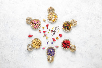Assortment of dry tea in golden vintage mini plates.Tea types background:hibiscus,chamomile,mixed black tea,dry roses,butterfly pea tea