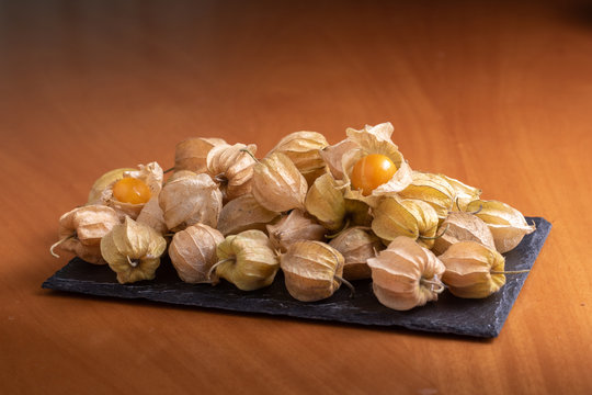 Ripe physalis isolated on a wooden background. Physalis Peruviana 
