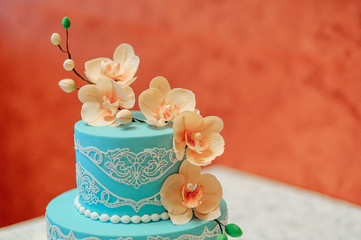blue cake with a branch of orchids