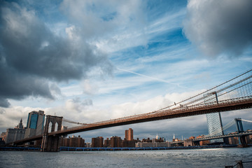 Scenic view of Brooklyn Bridge crossing to Manhattan at Sunset. Dramatic Sky
