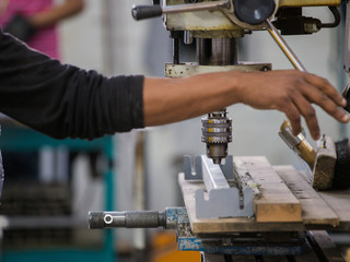 Close up image of a drill press being used in a factory