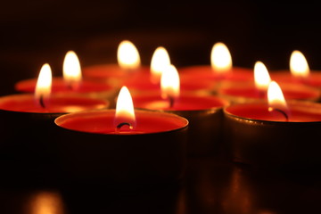 Group of red candles burning in the dark