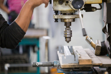 Close up image of a drill press being used in a factory