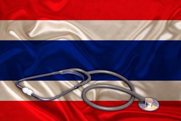 doctor’s tool, medical stethoscope, lies on the silk national flag of the state of Thailand, concept of tourism, insurance, health, pediatrics