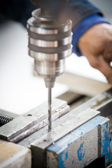 Close up image of a drill press being used in a factory