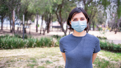 Young woman in park with face mask