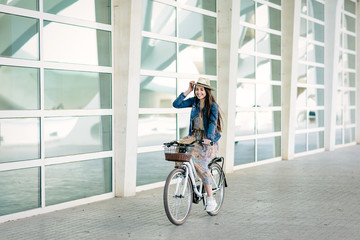 Young girl enjoys the city with her rental urban bike - obrazy, fototapety, plakaty