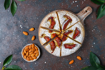 Homemade rustic plum cake with powdered sugar and almond,top view