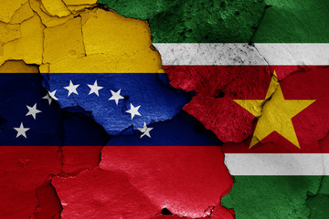 flags of Venezuela and Suriname painted on cracked wall