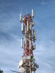 Modern tower with huge complex of telecommunication antennas on old bricks house hidden in pine trees.  Mountain trail over Pintal Vermell peak, Mallorka island, Spanish  Balears islands.