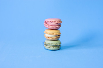 three coloured macarons on a blue background