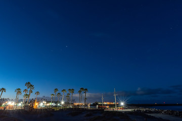 Star constellations still visible in the dawn sky as morning breaks over this California beach park.