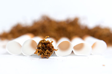 cigarette around cigarette liners in the background a handful of tobacco on a white background. isolate. close up