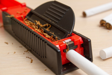 machine for filling cigarettes with tobacco and cigarettes on a light tree