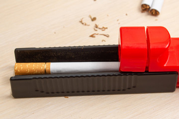 machine for filling cigarettes with tobacco and cigarettes on a light tree