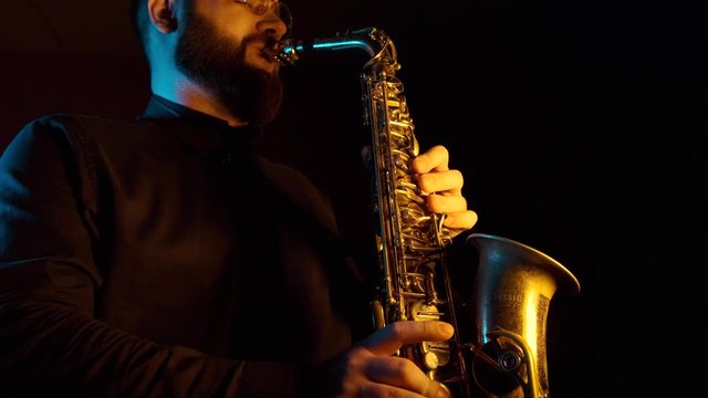 handsome man playing the saxophone, black background, isolated, solo