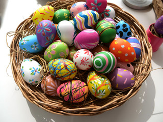 Easter eggs, in a wooden basket in various colors, isolated on a white background