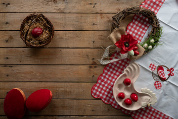 Easter background with easter tablecloth, decorative wreath, decorative eggs and a decorative rooster for red eggs