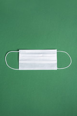 Surgical mask over minimalist green background