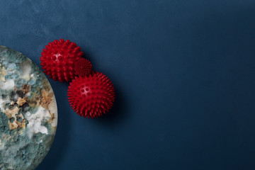 Red massage balls on a contrasting textured background. The abstract appearance of the coronavirus. Pandemic model. Infected planet. Rapid spread of  COVID-19. Place for text