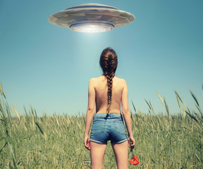 Een meisje in het veld kijkt naar een UFO in de lucht. Fictiescène met buitenaards ruimteschip. Foto met 3D-renderingelement
