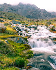 River, grass and mountains scene