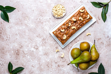 Homemade rustic chocolate cake with pear and cashew nuts,top view