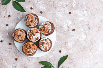 Coffee cupcakes decorated with whipped cream and coffee beans.