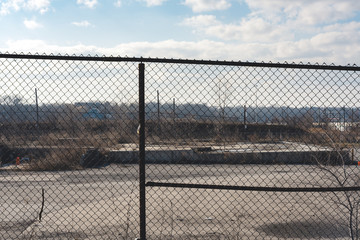 fence with barbed wire in front of barren undeveloped landscape