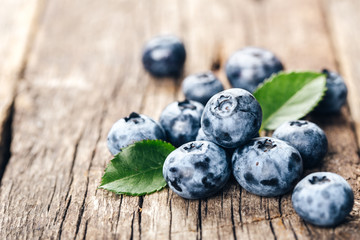 Freshly picked blueberries on wooden background. Healthy eating and nutrition.