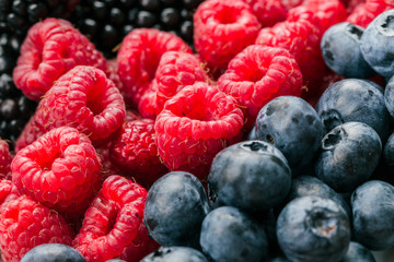 Fresh Summer Berries mix with Raspberry, Red currant, Blueberry and Blackberry on wood background.
