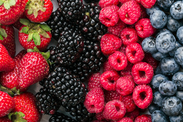 Fresh Summer Berries mix Background with Strawberry, Raspberry, Red currant, Blueberry and Blackberry.