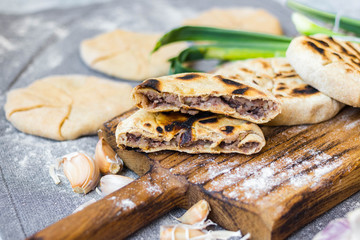 Tortilla mexican bread cakes stuffed with red kidney beans filling. Lobiani homemade georgian traditional pie. Vegan, vegetarian food. Wooden board.