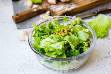 Green herbal leaves fresh detox salad in glass bowl. Vegan, vegetarian healthy diet food