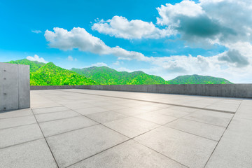 Empty square floor and green mountain nature landscape on sunny day.