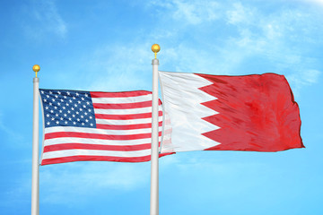 United States and Bahrain  two flags on flagpoles and blue cloudy sky