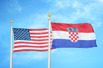 United States and Croatia two flags on flagpoles and blue cloudy sky