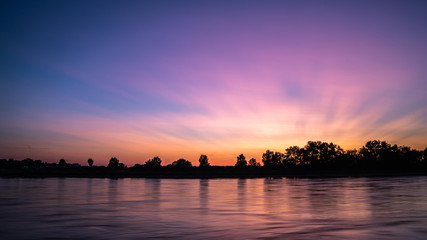 Naklejka premium Beautiful lakescape at sunset; colorful sunset in the sky